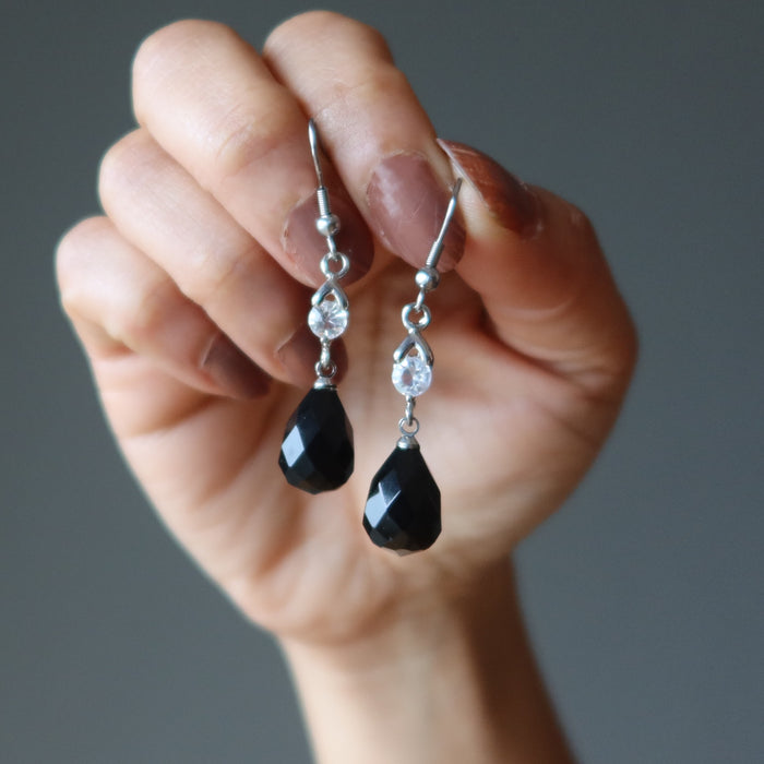 hands holding black onyx earrings