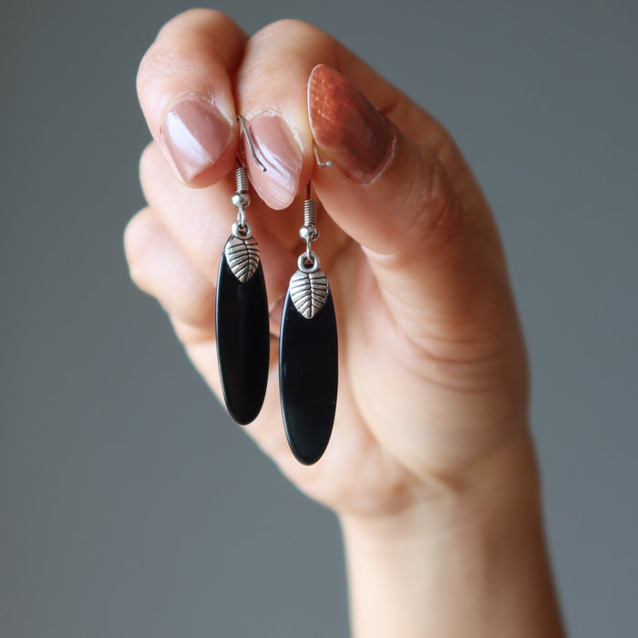 hand holding black onyx oval earrings showing the back