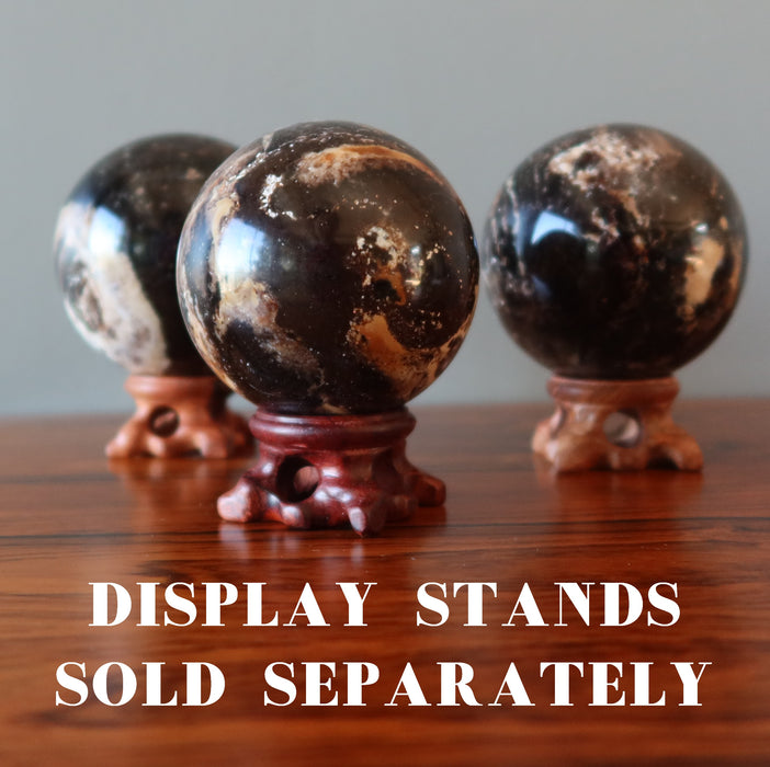 three brown opal spheres on fancy wood stands, which are sold separately
