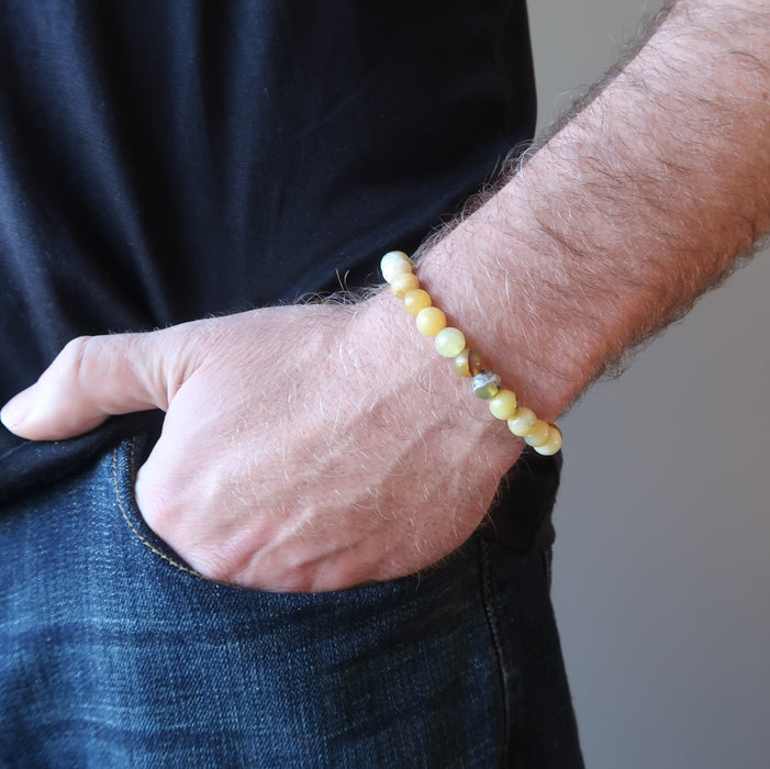 hand in jeans pocket wearing a round yellow opal beaded stretch bracelet