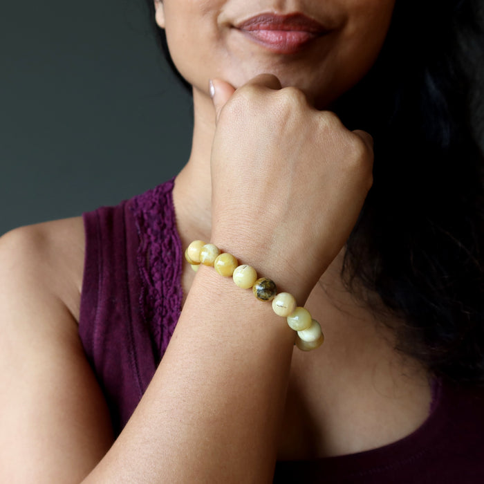 model with hand on chin wearing yellow opal beaded bracelet