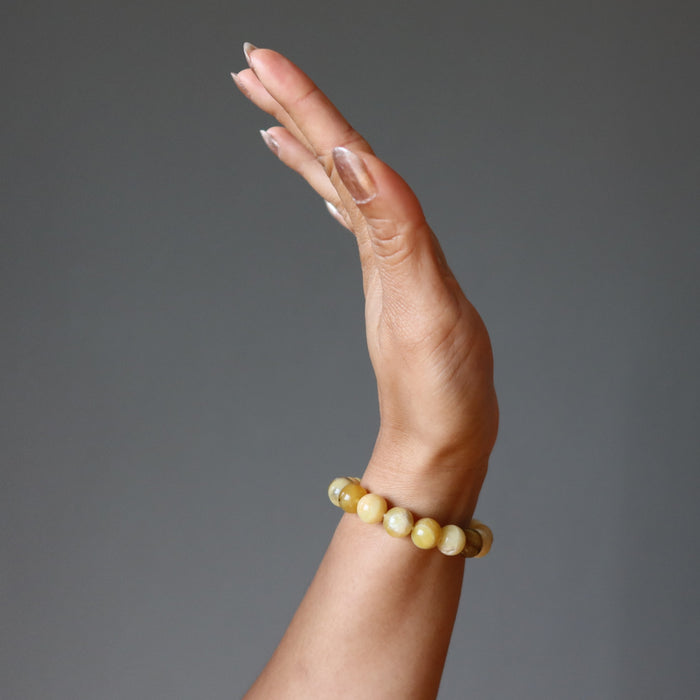 woman's hand wearing yellow opal beaded bracelet