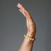 woman's hand wearing yellow opal beaded bracelet