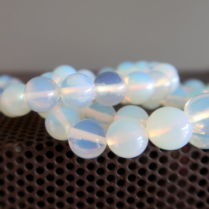 a stack of pearly white opalite bracelets with rainbow tint