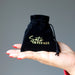 black velveteen pouch with gold "satin crystals" print in palm of hand