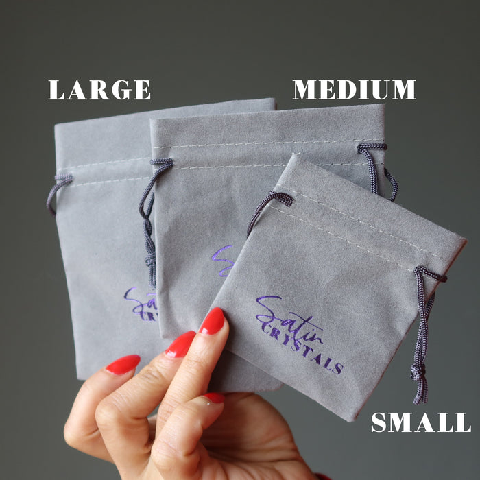 hand holding gray velvetten pouch with purple "satin crystals" print in large, medium and small sizes