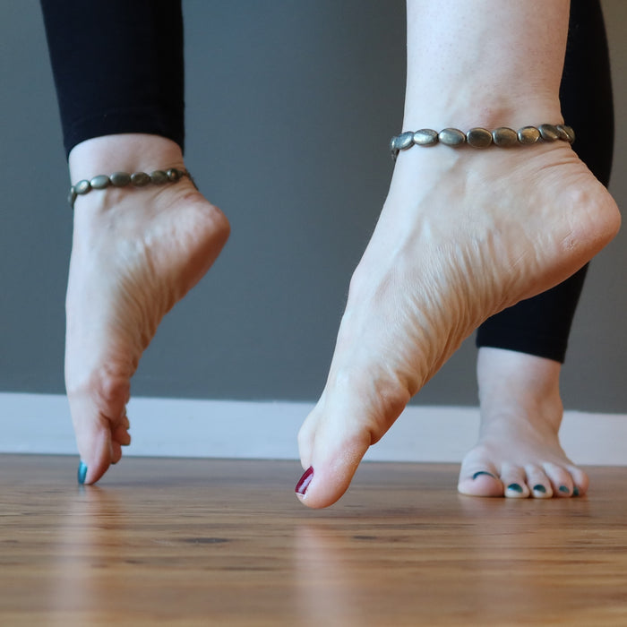 two pointed feet wearing pyrite oval anklets
