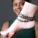 sheila of satin crystals holding a mannequin foot wearing three pyrite anklets