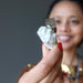 sheila of satin crystals holding pyrite cube on white matrix