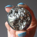 hand holding gold pyrite geode sphere