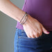 hand in jeans pocket wearing a faceted pyrite on 3 coils of gunmetal beaded memory wire bracelet