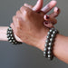 man and woman's hands clasping wearing pyrite bracelets