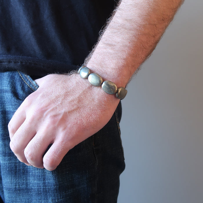 man hand in jeans pocket wearing pyrite oval stretch bracelet