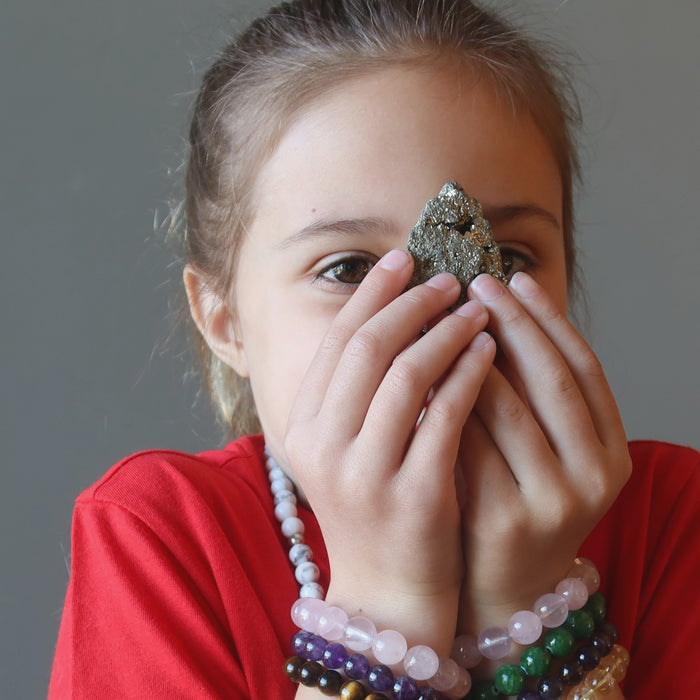 female kid with pyrite cluster at her third eye