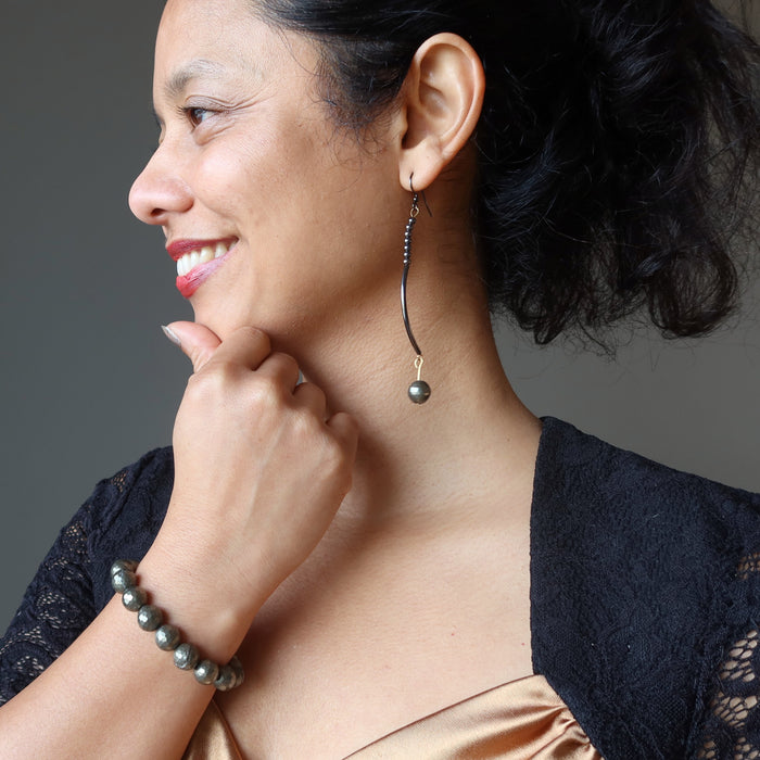 sheila of satin crystals wearing pyrite curve earrings and faceted pyrite bracelet