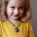 female child wearing pyrite rose and chalcedony necklace