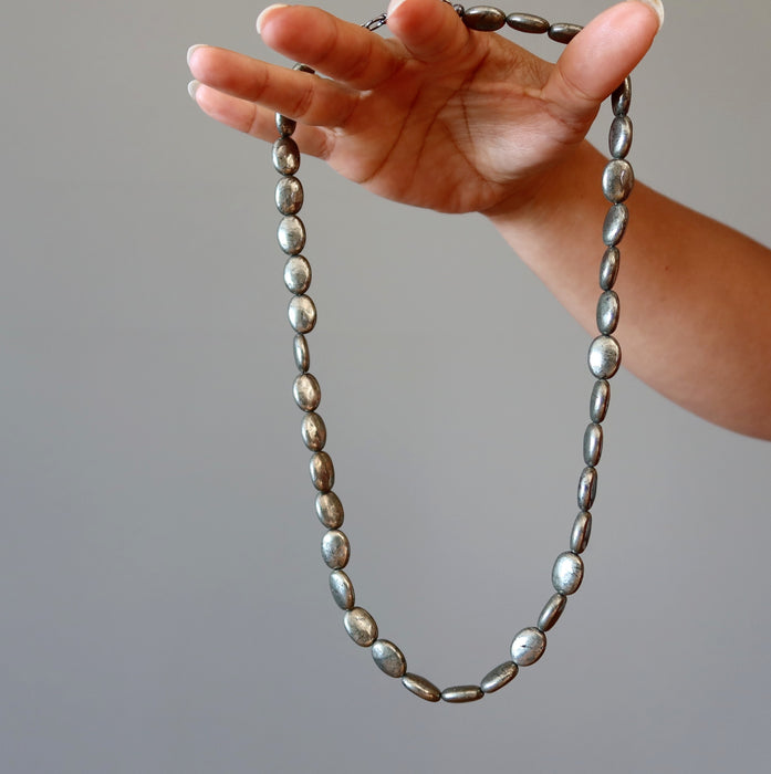 hand holding pyrite oval necklace