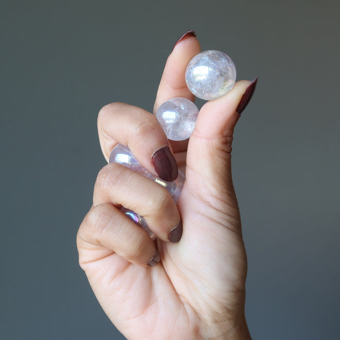hand holding aura quartz balls