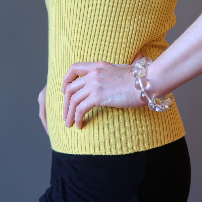 female model with hand on hip wearing clear quartz bracelet
