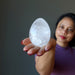 sheila of satin crystals holding on her palm Clear Rainbow Quartz Egg