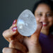 sheila of satin crystals holding Clear Rainbow Quartz Egg