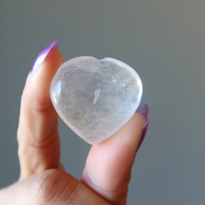 holding a small Clear Quartz Heart