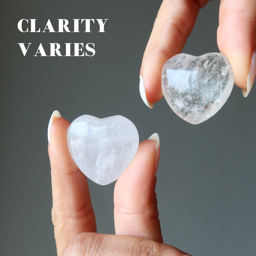 holding different clarities between two Clear Quartz Hearts