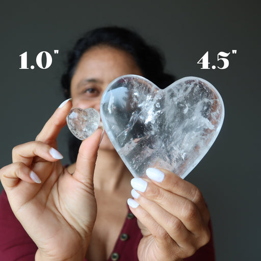 sheila of satin crystals holding 1" and 4.5" Clear Quartz Hearts