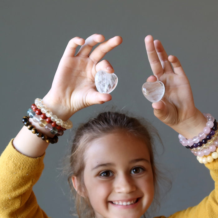 Zoe of Satin Crystals raising hands holding Clear Quartz Hearts