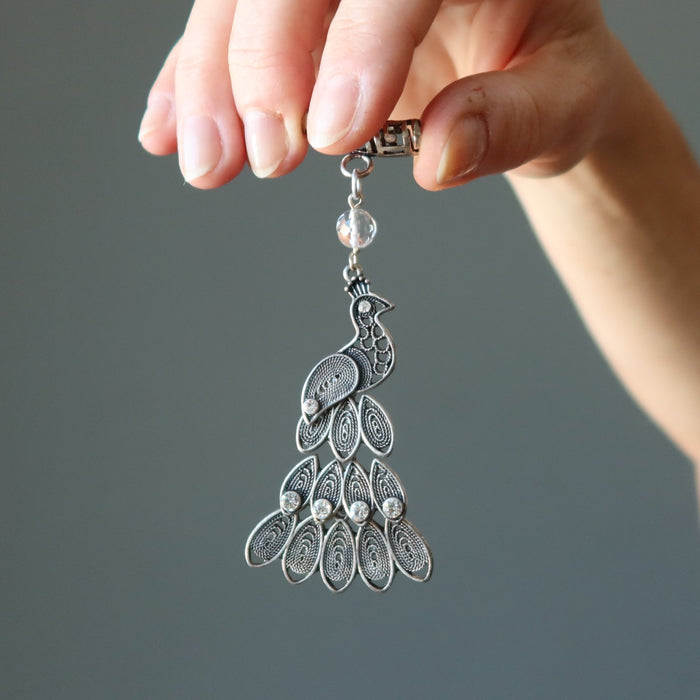 holding Clear Quartz decorated on silver Peacock Pendant  