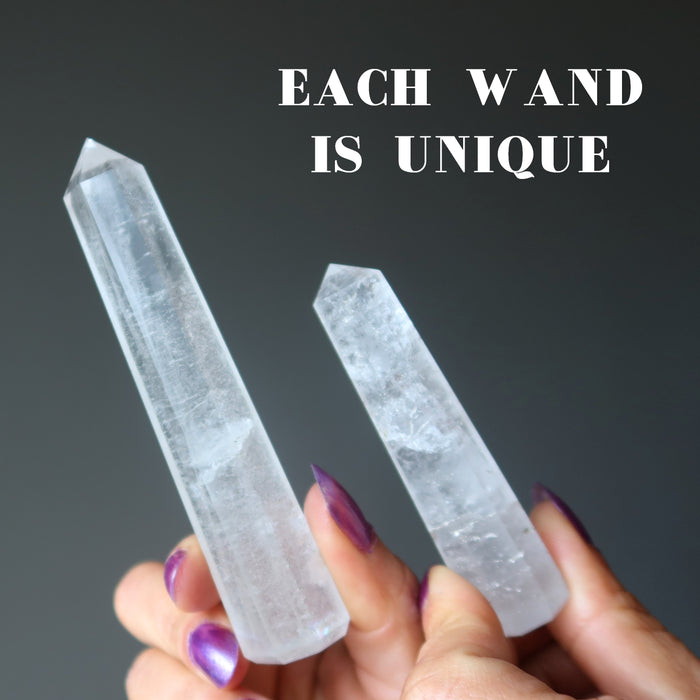 hands holding two unique faceted Clear Quartz Wand Towers