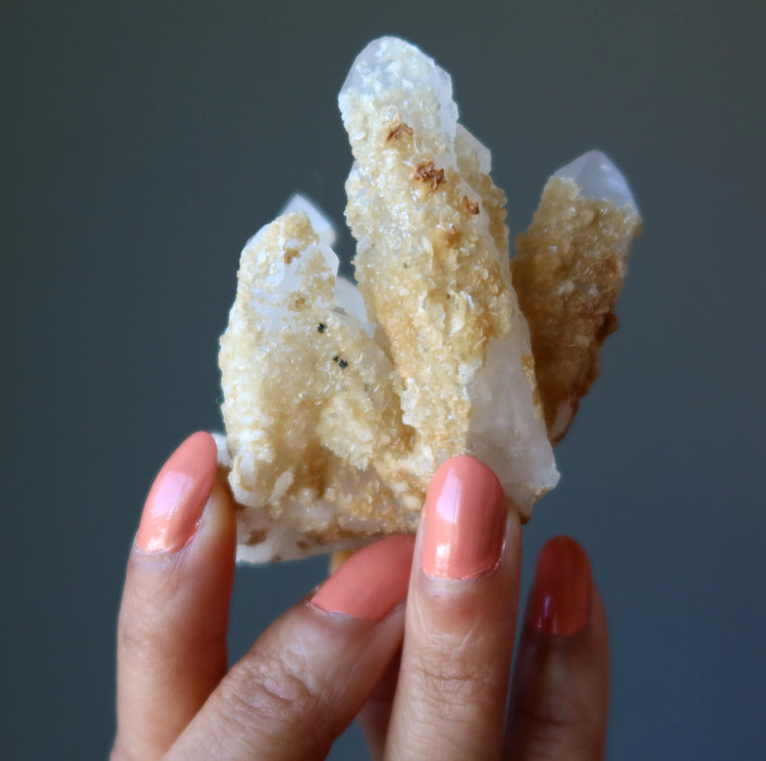 hand holding raw white quartz cluster