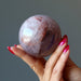 hand holding lavender quartz sphere