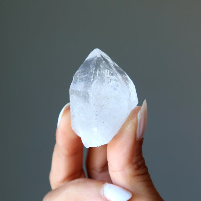 holding one raw clear quartz point