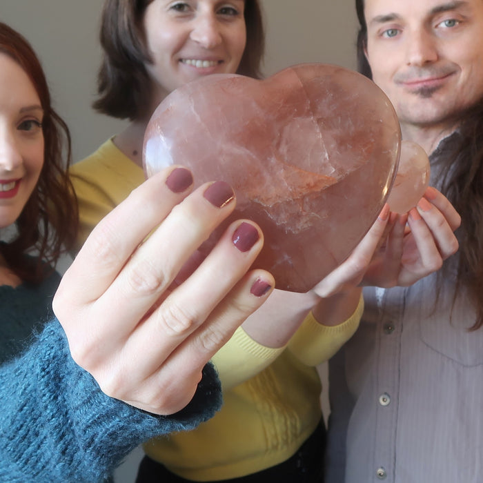 two women and man holding red fire quartz hearts