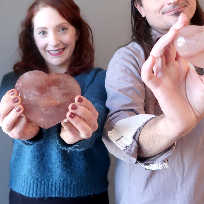 man and woman holding red fire quartz hearts
