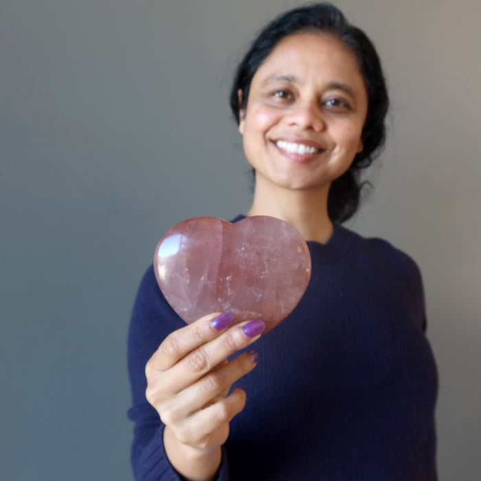 woman holding red fire quartz heart at heart chakra