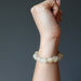 hand wearing a golden angel hair rutilated quartz stretch bracelet