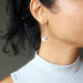 woman modeling snow quartz dangle earrings
