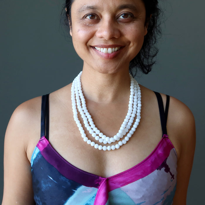 sheila satin of satin crystals wearing Snow white Quartz round beads strung in 3-strands of necklace on an adjustable tasseled clasp