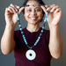 sheila satin of satin crystals holding Jasper and apatite with Quartz donut medallion necklace