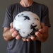 man's hands holding big tourmalined quartz sphere
