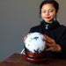 sheila of satin crystals sitting with hands on a quartz tourmaline sphere for gazing