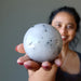 woman holding quartz tourmaline sphere