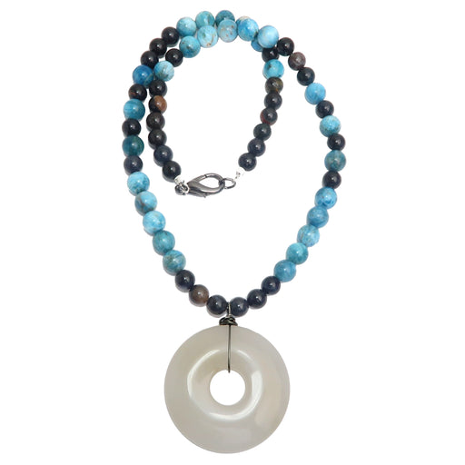 Quartz donut medallion hanging from a necklace beaded with crackly blue Apatite and an assortment of dark Jasper beads secured with a gunmetal lobster claw clasp. 