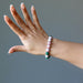 hand wearing a rhodochrosite and malachite stretch bracelet