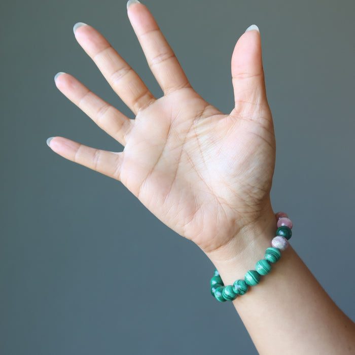 hand wearing a rhodochrosite and malachite stretch bracelet