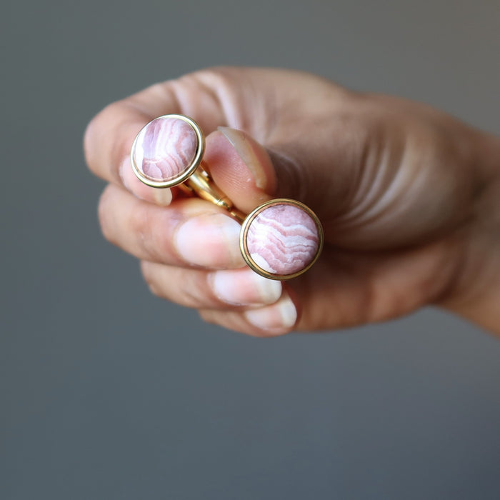 hands holding pink rhodochrosite gold cufflinks