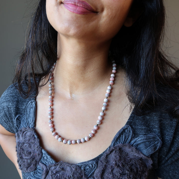 female modeling rhodochrosite necklace