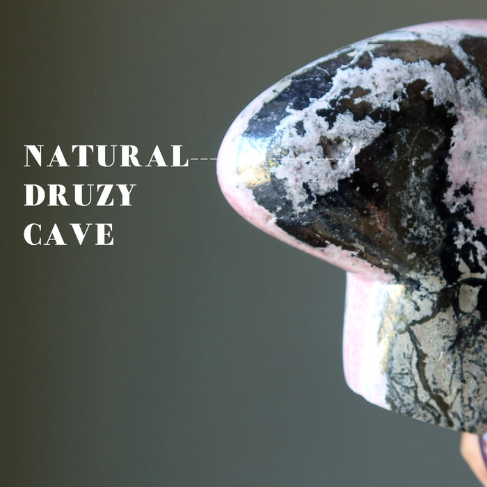 natural druzy cave in woman holding large rhodonite bear crystal